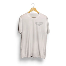 Cargar imagen en el visor de la galería, White t-shirt with 'Big Dog Coffee' text on a wooden hanger against a white background